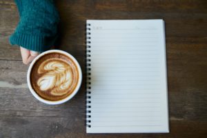 notebook blank page with a cup of coffee next to it