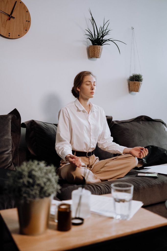 person on a couch in a cross legged position Mindful breathing meditation. 