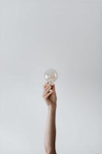 Hand holding a lightbulb unlocking Creativity