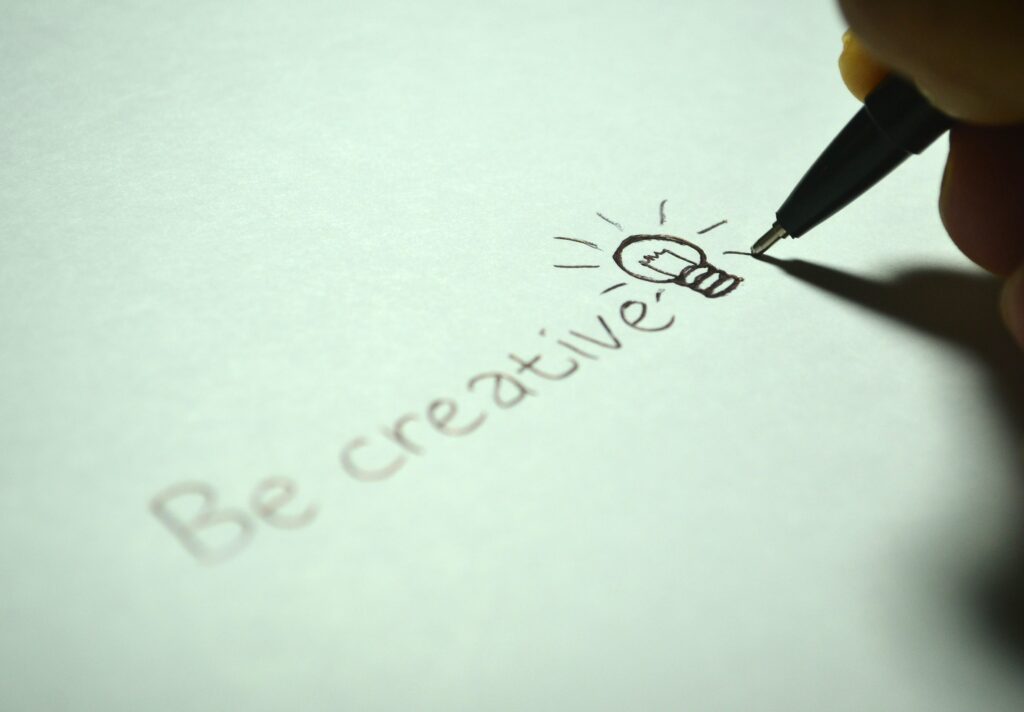 "Be creative" written out on paper with a light bulb drawn at the end Unlocking Creativity